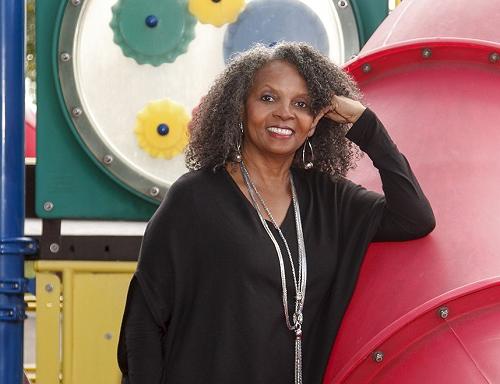 Dr. Rosemarie Allen standing in front of a playground.
