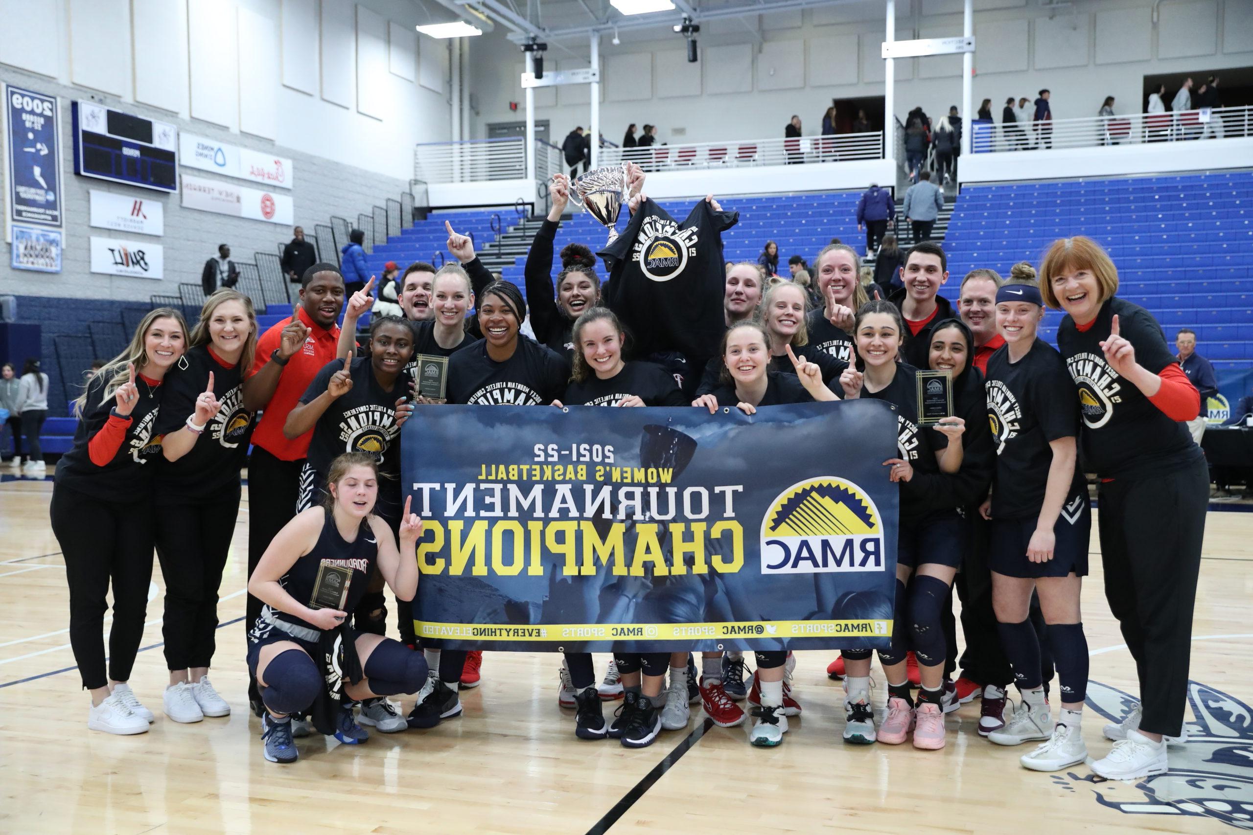 Roadrunners women's basketball team with the RMAC Championship banner after the title game in 2022.