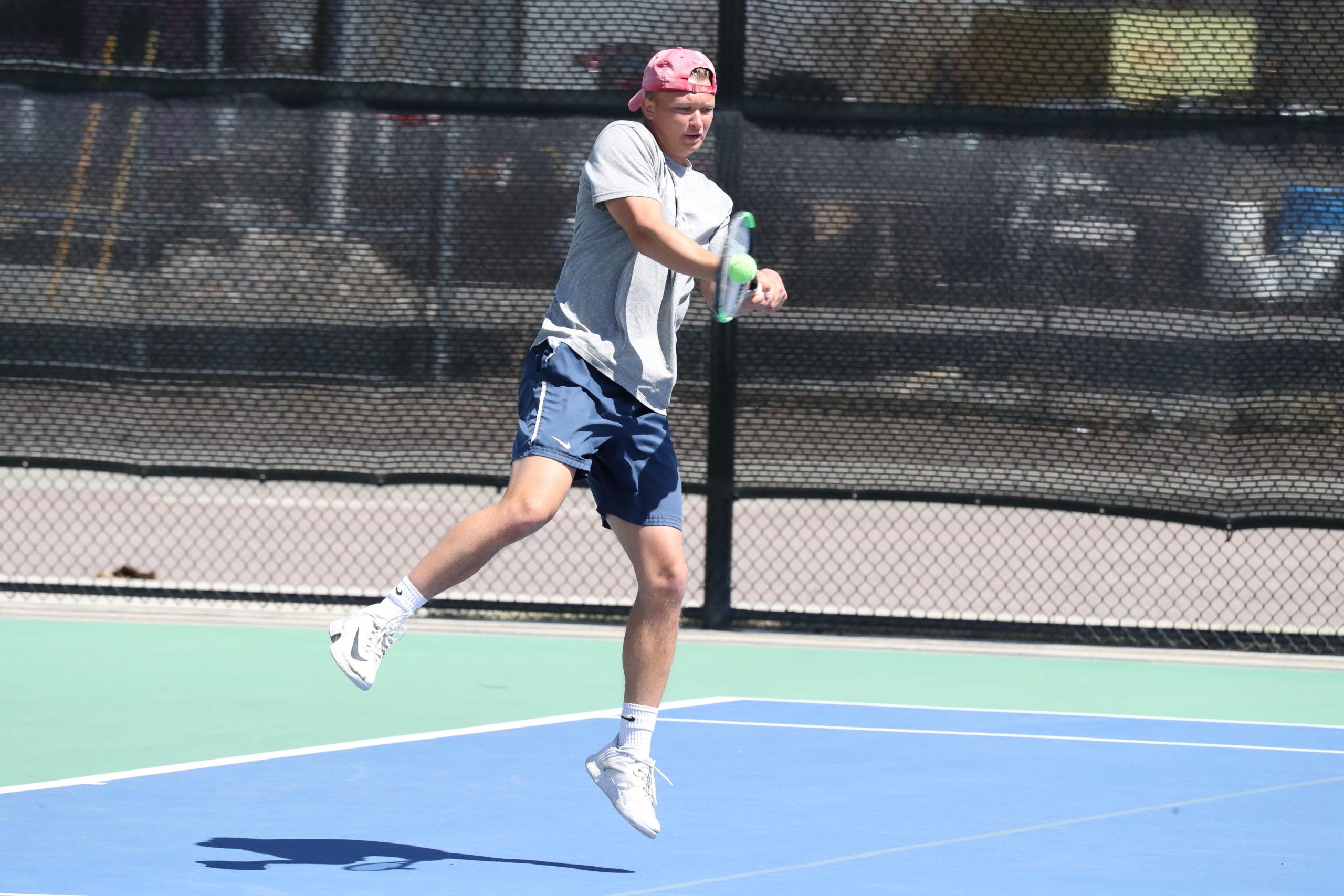 Men's tennis player David Kijak makes contact on a back-handed shot during a match in 2022.