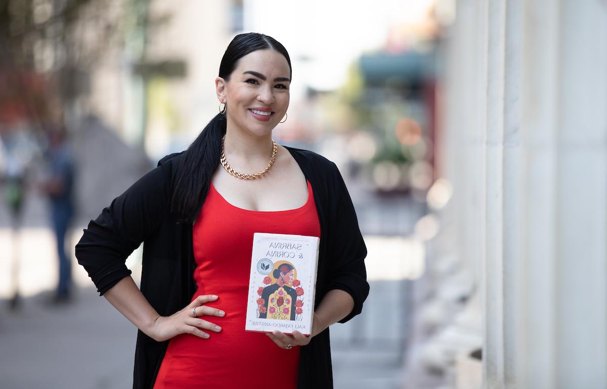 作家Kali Farjardo-Anstine拿着她的书《Sabrina》 & Corina