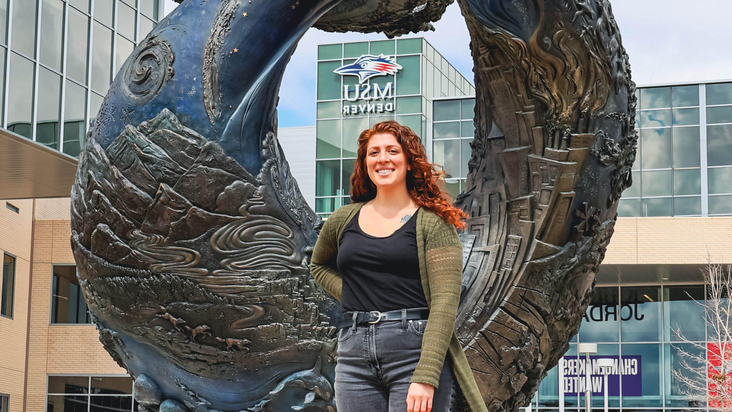 Natassa Christides standing in front of the One World One Water statue in front of the Student Success Building