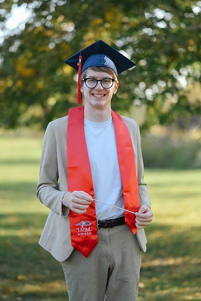 Samuel Cooper headshot in graduation hat